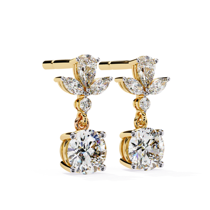 Charming yellow gold drop earrings with a dazzling round diamond at the base, accompanied by graceful pear-shaped diamonds arranged in a leaf-like pattern for an elegant, nature-inspired design.